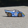 Blue and white race car pin with number 36 on a textured surface